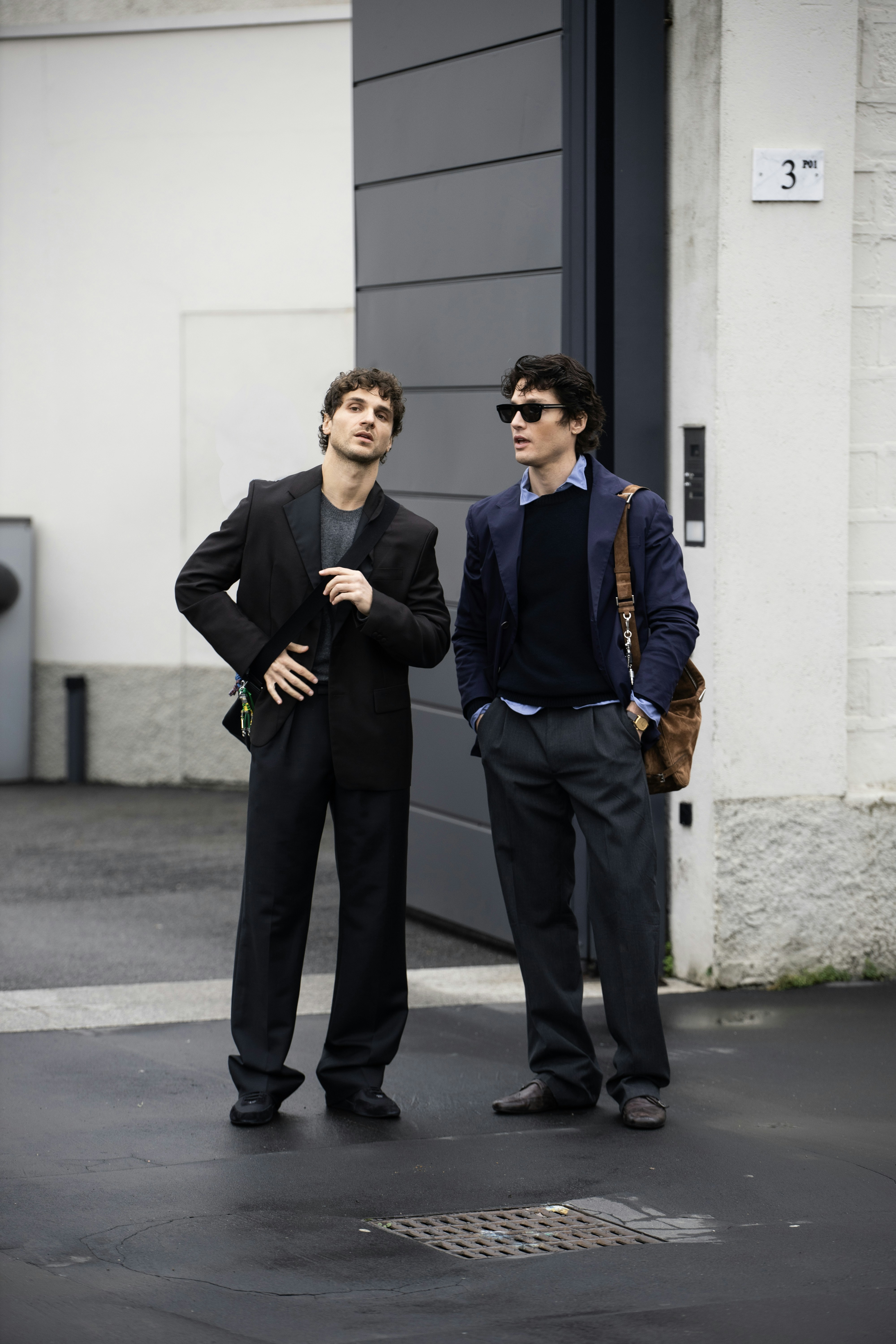 Two men standing next to each other in front of a building